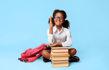 Akıllı Siyah İlköğretim Okulu Kız Studio Sarı Arka Plan Üzerinde Kitap Stack Oturan El Raising. Boş Alan