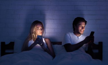 Hile Kavramı. Sadakatsiz Koca Gece Yatakta Karısı ile Yatan Cep Telefonu Sohbet. Seçici Odaklama, Düşük Işık