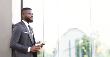 İş uygulaması konsepti. Afrikalı Girişimci Adam Şehir Bölgesi 'ndeki Ofis Yakınındaki Akıllı Telefon Kullanıyor. Boşluğu Kopyala