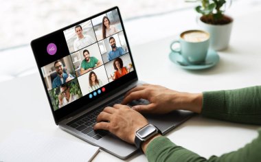 Freelancer bir dizüstü bilgisayarın önünde oturuyor ve birden fazla kişinin katıldığı çevrimiçi bir video konferansına katılıyor.