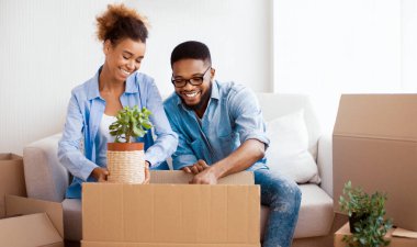 Taşınma Evi. Mutlu Afro-Çift Paketleme Kutusu Kapalı Koltukta Birlikte Oturuyorlar. Seçici Odaklanma