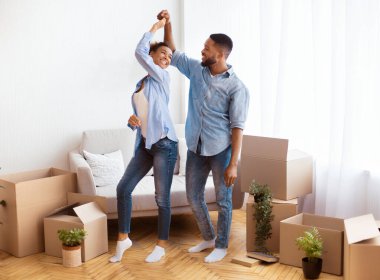 Neşeli Siyah Çift Yeni Evde Taşınan Kutular Arasında Dans Ediyor. Yeniden Yerleştirme Konsepti Kutlanıyor