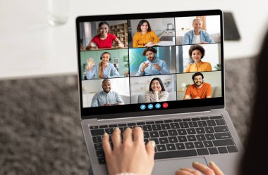 Bir kadın dizüstü bilgisayarda yazı yazıyor, sekiz kişiyle video konferansına katılıyor. Video ekranında katılımcıların dokuz farklı videosu gösteriliyor
