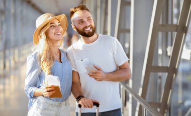 Rüya tatili. Havaalanında bir çift kalkış için bekliyor, yana bakıyor, boş yer var.