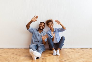 Yeni Ev 'de tadilat. Gülümseyen Afro Çiftin İç Tasarımı Kendi Evine Taşındıktan Sonra Yerde Oturuyor