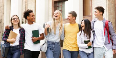 Neşeli üniversite öğrencileri okuldan sonra birlikte yürüyor, kampüste dinleniyorlar.