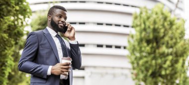 Her zaman temas halinde. Şehirde Kahve Molası Sırasında Cep Telefonuyla Konuşan Afro-Amerikan İşadamı. Boş alan