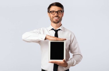 İş Uygulaması. Studio Beyaz Arka Plan üzerinde boş tablet bilgisayar ekranı gösteren neşeli adam. Mockup