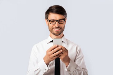 Pozitif iş adamı cep telefonuyla mesajlaşıyor. Beyaz arka planda duruyor. Stüdyo Çekimi, Boş Alan