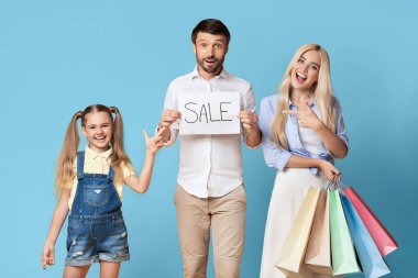 Üç kişilik mutlu bir aile satışı heyecanla kutluyor. Baba elinde kocaman bir gülümsemeyle 