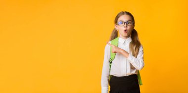 Vay canına, şuna bak. Şok Schoolgirl Studio Sarı Arka Plan Kenara Parmak İşaret. Metin için boş alan içeren panorama