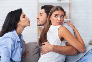 Kıskançlık ve sadakatsizlik. Kız, erkek arkadaşını aldatırken, erkek arkadaşını öpüyor. Evde, koltukta birlikte oturuyor.