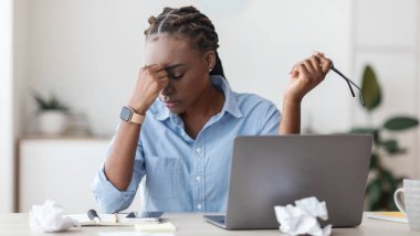 Son gün stresi. Ofiste İşyerinde Burun Köprüsü 'ne Masaj Yapan Çok Çalışan Siyah Kadın Girişimci, Dizüstü bilgisayar kullandıktan sonra Tükenmiş