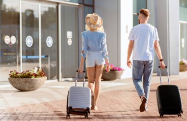 Normal Yaşam Kavramına Dönüş. Havaalanı cam kapısına doğru giden iki turistin arka görüntüsü, kopyalama alanı