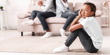 Aile Tartışmaları Konsepti. Üzgün Afrikalı Amerikalı küçük kız, tartışmalarından sonra ailesinden ayrı oturuyor. Çocuklarına odaklanıyor.