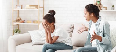 Kız kardeşler kavga ediyor. Bir Afrikalı kız kardeş diğerine bağırıyor, onu ağlatıyor, evin içinde.