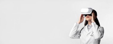 Yüksek teknoloji tıbbı. Kadın Doktor Beyaz Stüdyo Arka Plan Over Tıbbi Tanı için Sanal Gerçeklik Kulaklık kullanma. Boş Alan