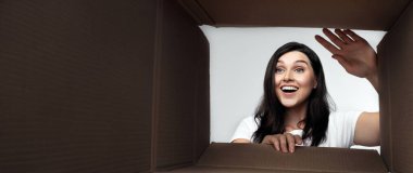 Teslimat Servisi. Heyecanlı Kız Boş Karton Kutu içinde bakıyor. Alt Görünüm