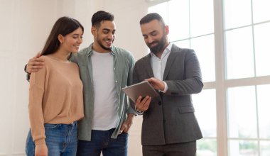 Milenyum Çifti Yeni Daire Satıyor, Boş Oda 'da Bekliyor, Profesyonel Emlakçı Takım Elbiseli Dijital Tableti İnşaat Projesiyle Gösteriyor, Ev Planını Tartışıyor, Mutlu Aile' ye Daire Satıyor