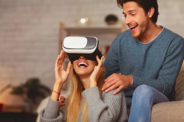Heyecanlı Çift Evde Eğlenmek Videogame Oynarken Sanal Gerçeklik Gözlükleri kullanarak. Seçici Odak