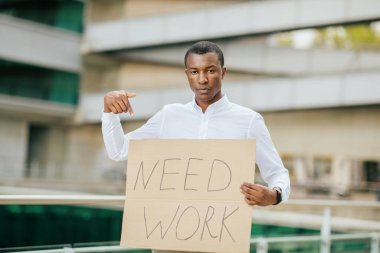 Beyaz tişörtlü Afro-Amerikalı genç bir adam elinde 