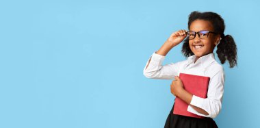 Küçük Afrikalı Öğrenci Kucağında Gülümseyen Gözlük Gözlüğü Poz Veren Sarı Stüdyo Arkaplanı. Okula Dönüş Konsepti.