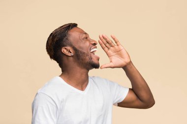 Dikkat! Afro Adam El ele tutuşuyor Ağız kenarında duruyor Sarı Stüdyo Arkaplanında duruyor.