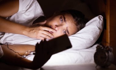 Uykusuzluk ve anksiyete. Stresli Kız Gece Yatak Odasında Yatan İnternet Tarama Cep Telefonu Kullanma. Düşük Işık