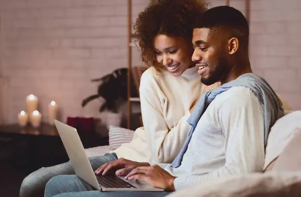 stock image Young married couple using laptop at cozy winter evening, resting at home, free space