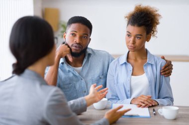 Ciddi genç Afro çift ofiste mali danışma sırasında yatırım danışmanı dinlerken. Seçici Odak