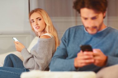 Sadakatsizlik. Kadın, kocasını cep telefonunda başka bir kadınla telefonda mesajlaşırken yakalamış. Seçici Odaklanma