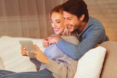 Birlikte Akşam. Tablet Bilgisayarda Film İzleyen Sevgi Dolu Çift Kanepede Kapalı Oturuyor. Seçici Odak