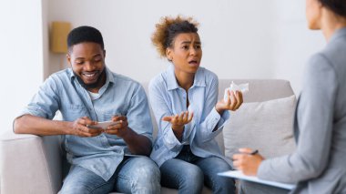 Gadget ve Telefon Bağımlılığı. Hüsrana uğramış Afrikalı Amerikalı Eş, kocanın cep telefonunu aşırı kullanmasından şikayetçi. Seçici Odaklanma