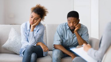 İlişkiden yoruldum. Üzgün Afro-Amerikan çift evlilik terapistleri ofisinde kanepede oturuyor. Seçici odak