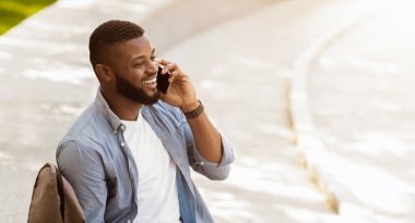 Hoş bir karar. Yakışıklı milenyum çocuğu telefonda konuşuyor ve gülüyor, boş alanı olan bir panorama.
