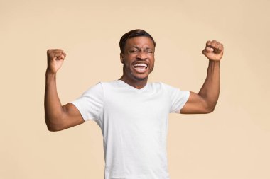 Duygusal Afro Adam, Sarı Arkaplanda Ayakta Duruşunu Kutlayan Yumrukları Sarsıyor. Stüdyo Çekimi