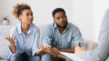 Çiftler Terapisi Seansı. Afro-Amerikan Karısı Kocası Yanında Kanepede Oturan Danışman Konuşuyor. Seçici Odak