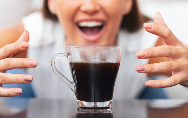 Caffeine Craving. Unrecognizable Woman Reaching For Cup Of Coffee Sitting On Sofa Indoor. Selective Focus, Cropped
