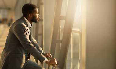 Uçağı bekle. Havaalanındaki Pencereden Bakan Afro-Amerikalı İş Adamı, Uzayı Kopyala