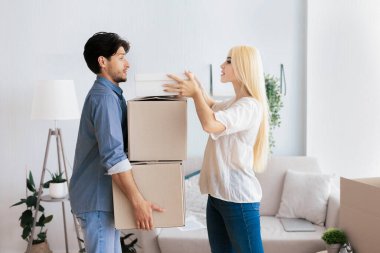 Apartman hazırlığı. Genç çift, eski evlerindeki eşyalarıyla birlikte kutuları taşıyorlar. Boş Boşluk