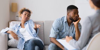 İlişkide Kayıtsızlık. Onun Kayıtsız Karısı Kanepede Oturan Danışman şikayet ederken Afro-Amerikan Kocası Uzağa Bakıyor.