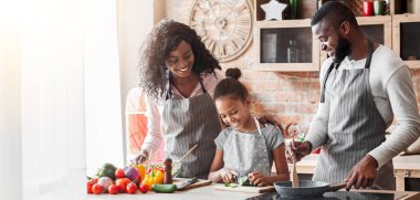 Küçük Afrikalı kız ilk yemek yapıyor, mutfakta neşeli anne ile birlikte vakit geçirmek, boş alan