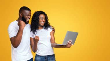 Neşeli Afrikalı Amerikalı Millennial Guy ve Kız Win Laptop kutluyor, sarı arka plan üzerinde gülümseyerek, kopya alanı