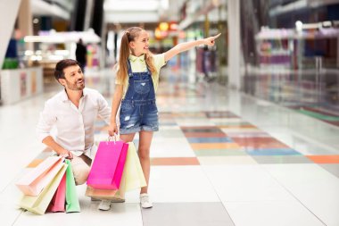 Alışveriş. Alışveriş merkezi'nde babasıyla birlikte vitrine parmakla işaret eden küçük kız. Boş Alan
