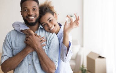 Ev sahibiyim. Gülümseyen Afro Eşler, taşındıktan sonra Yeni Ev 'de Kameraya Kucaklama Anahtarı Gösteriyor. Seçici Odaklanma