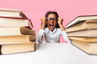 Küçük Siyah Schoolgirl Loudly Studio Sarı Arka Plan Üzerinde Kitap Yığınları Arasında Oturan Screaming. Ödev Yükü Kavramı.