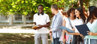 Kampüs hayatı. Sınıflar arasında dinlenen, sohbet eden ve gülümseyen neşeli ırklar arası öğrencilerin portresi.
