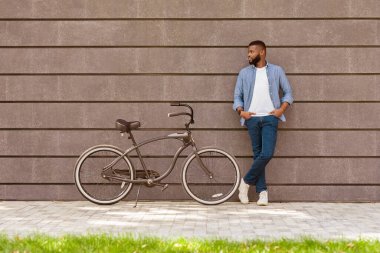 Şehir Yaşam Tarzı. Gri Şehir Duvarı Üzerinde Güzel Bisiklet Pozu Veren Yakışıklı Afro Adam