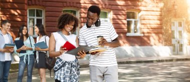 Bir çift Afrikalı Amerikalı Öğrenci Dışarıda durup Notepad 'da Birlikte Yazılan Sınıfları Kontrol Ediyor