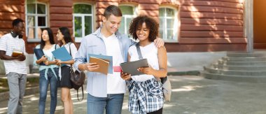 Siyahi sınıf arkadaşını kucaklayan neşeli öğrencinin portresi başarılı bir sınav kartıyla karşılanıyor..